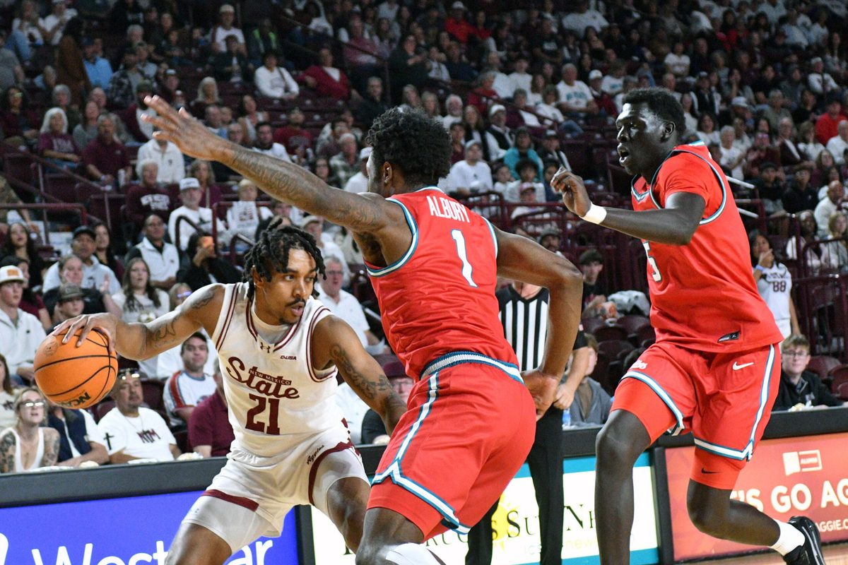 NMSU's Jemel Jones looks to make a pass to a teammate along the baseline as the Aggies took on the Lobos on Saturday night in Las Cruces.