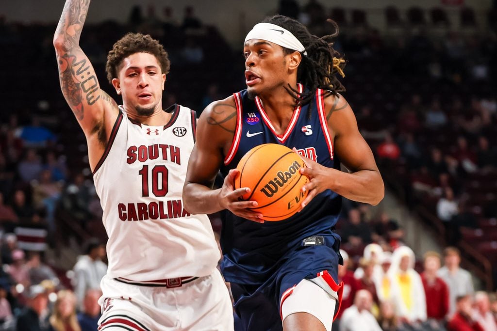 Nov 18, 2025; Columbia, South Carolina, USA; Radford Highlanders guard Dennis Parker (11) drives past South Carolina Gamecocks forward Myles Stute (10) in the second half at Colonial Life Arena. Mandatory Credit: Jeff Blake-Imagn Images