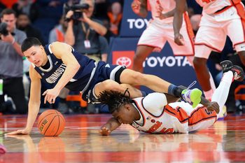 Nov 18, 2025; Syracuse, New York, USA; Monmouth Hawks forward Jason Rivera-Torres (1) and Syracuse Orange guard Bryce Zephir (55) battle for a loose ball during the second half at the JMA Wireless Dome. Mandatory Credit: Rich Barnes-Imagn Images