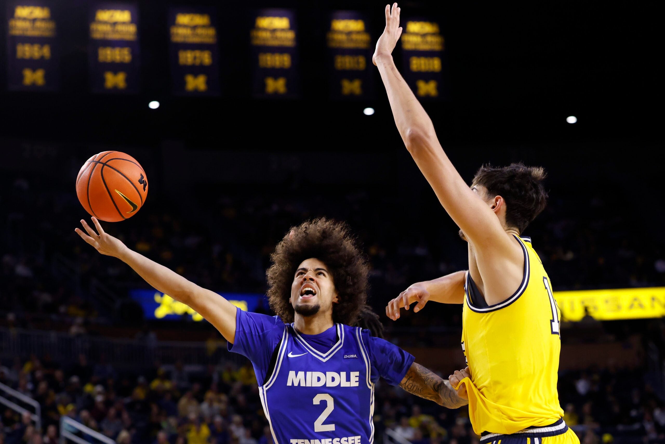 Nov 19, 2025; Ann Arbor, Michigan, USA; Middle Tennessee Blue Raiders guard Jahvin Carter (2) shoots defended by Michigan Wolverines center Aday Mara (15) in the second half at Crisler Center. Mandatory Credit: Rick Osentoski-Imagn Images