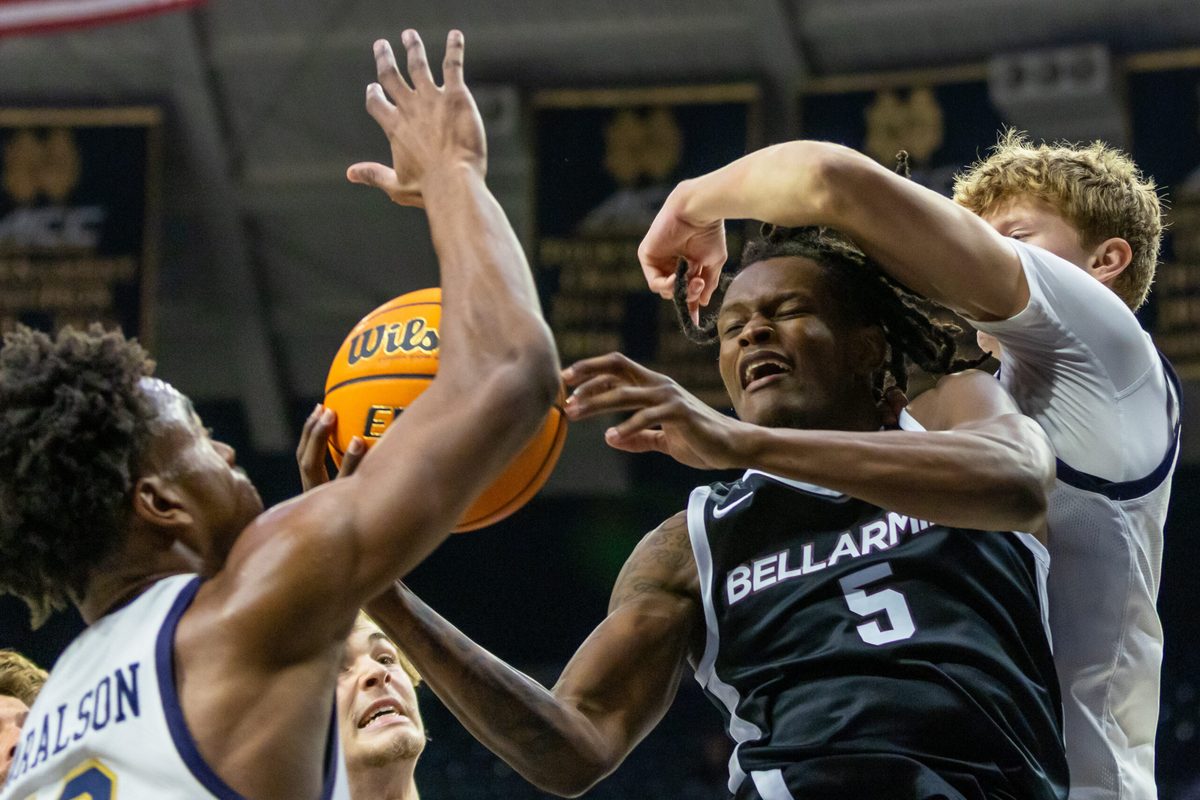 Nov 19, 2025; South Bend, Indiana, USA; Bellarmine Knights guard Myles Watkins (5) fights for a rebound against Notre Dame Fighting Irish guard Jalen Haralson, left, and forward Brady Koehler, right, during the second half at Purcell Pavilion at the Joyce Center. Mandatory Credit: Michael Caterina-Imagn Images