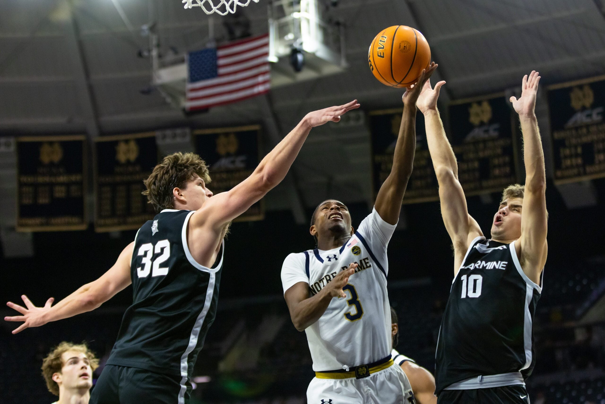 Nov 19, 2025; South Bend, Indiana, USA; Notre Dame Fighting Irish guard Markus Burton (3) puts up a shot as Bellarmine Knights forward Jack Karasinski (32) and guard Grant Whitaker (10) defend during the second half at Purcell Pavilion at the Joyce Center. Mandatory Credit: Michael Caterina-Imagn Images
