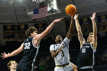 Nov 19, 2025; South Bend, Indiana, USA; Notre Dame Fighting Irish guard Markus Burton (3) puts up a shot as Bellarmine Knights forward Jack Karasinski (32) and guard Grant Whitaker (10) defend during the second half at Purcell Pavilion at the Joyce Center. Mandatory Credit: Michael Caterina-Imagn Images