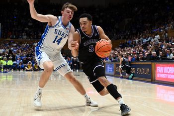 Nov 21, 2025; Durham, North Carolina, USA;Niagara Purple Eagles guard Justin Page (5) drives to the basket as Duke Blue Devils forward Nikolas Khamenia (14) defends during the first half at Cameron Indoor Stadium. Mandatory Credit: Rob Kinnan-Imagn Images