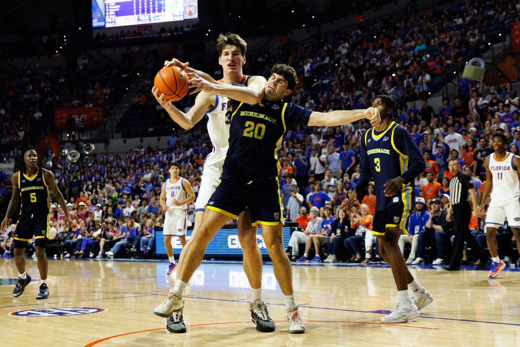 Nov 21, 2025; Gainesville, Florida, USA; Florida Gators center Olivier Rioux (32) and Merrimack Warriors forward Todd Brogna (20) battle for a rebound during the second half at Exactech Arena at the Stephen C. O'Connell Center. Mandatory Credit: Matt Pendleton-Imagn Images