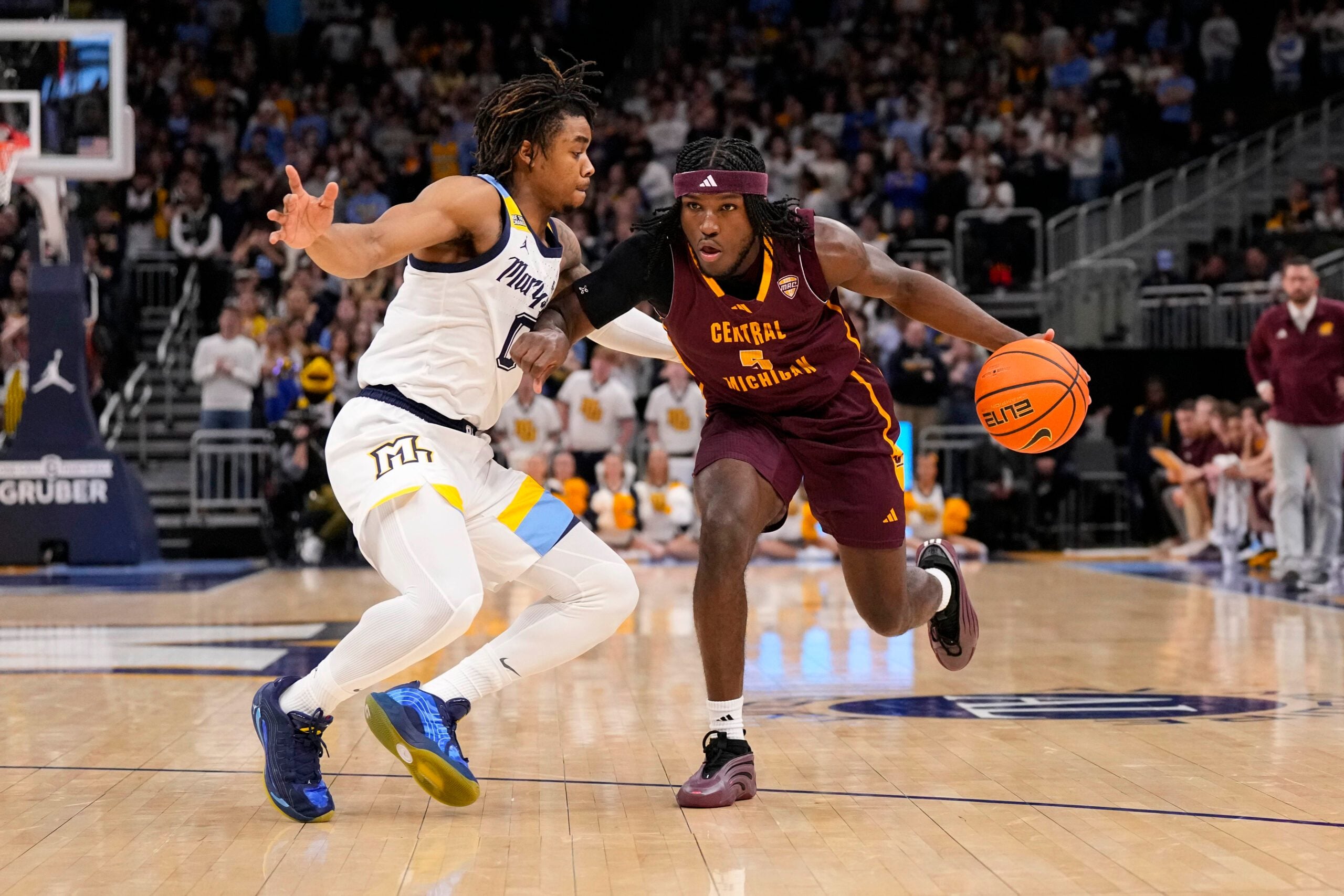Nov 22, 2025; Milwaukee, Wisconsin, USA;  Central Michigan Chippewas guard Tamario Adley (5) drives for the basket against Marquette Golden Eagles guard Nigel James Jr. (0) during the first half at Fiserv Forum. Mandatory Credit: Jeff Hanisch-Imagn Images