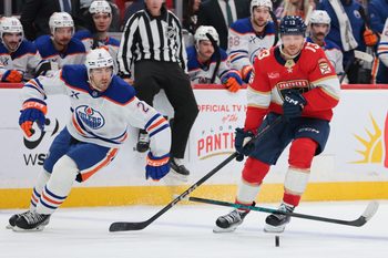 Nov 22, 2025; Sunrise, Florida, USA; Florida Panthers center Sam Reinhart (13) moves the puck against Edmonton Oilers defenseman Evan Bouchard (2) during the third period at Amerant Bank Arena. Mandatory Credit: Sam Navarro-Imagn Images