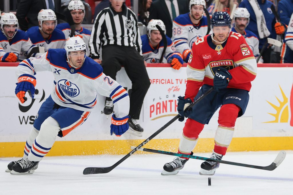 Nov 22, 2025; Sunrise, Florida, USA; Florida Panthers center Sam Reinhart (13) moves the puck against Edmonton Oilers defenseman Evan Bouchard (2) during the third period at Amerant Bank Arena. Mandatory Credit: Sam Navarro-Imagn Images