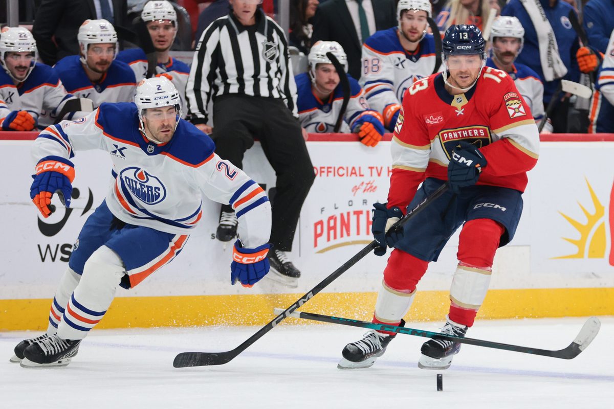 Nov 22, 2025; Sunrise, Florida, USA; Florida Panthers center Sam Reinhart (13) moves the puck against Edmonton Oilers defenseman Evan Bouchard (2) during the third period at Amerant Bank Arena. Mandatory Credit: Sam Navarro-Imagn Images