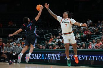 Nov 23, 2025; Coral Gables, Florida, USA; Delaware State Hornets guard Ponce James (1) steals a pass intended to Miami Hurricanes forward Shelton Henderson (7) during the first half at Watsco Center. Mandatory Credit: Sam Navarro-Imagn Images