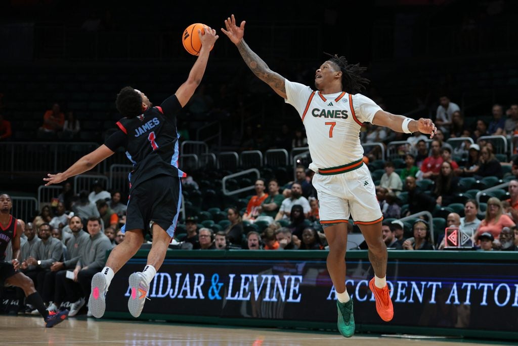 Nov 23, 2025; Coral Gables, Florida, USA; Delaware State Hornets guard Ponce James (1) steals a pass intended to Miami Hurricanes forward Shelton Henderson (7) during the first half at Watsco Center. Mandatory Credit: Sam Navarro-Imagn Images