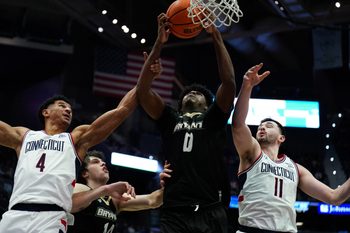 Nov 23, 2025; Hartford, Connecticut, USA; Bryant Bulldogs forward Ii Ashley Sims (0) works for the ball against UConn Huskies forward Dwayne Koroma (4) and forward Alex Karaban (11) in the second half at Peoples Bank Arena. Mandatory Credit: David Butler II-Imagn Images