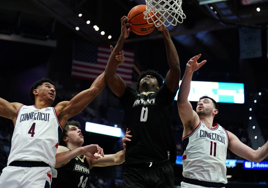 Nov 23, 2025; Hartford, Connecticut, USA; Bryant Bulldogs forward Ii Ashley Sims (0) works for the ball against UConn Huskies forward Dwayne Koroma (4) and forward Alex Karaban (11) in the second half at Peoples Bank Arena. Mandatory Credit: David Butler II-Imagn Images