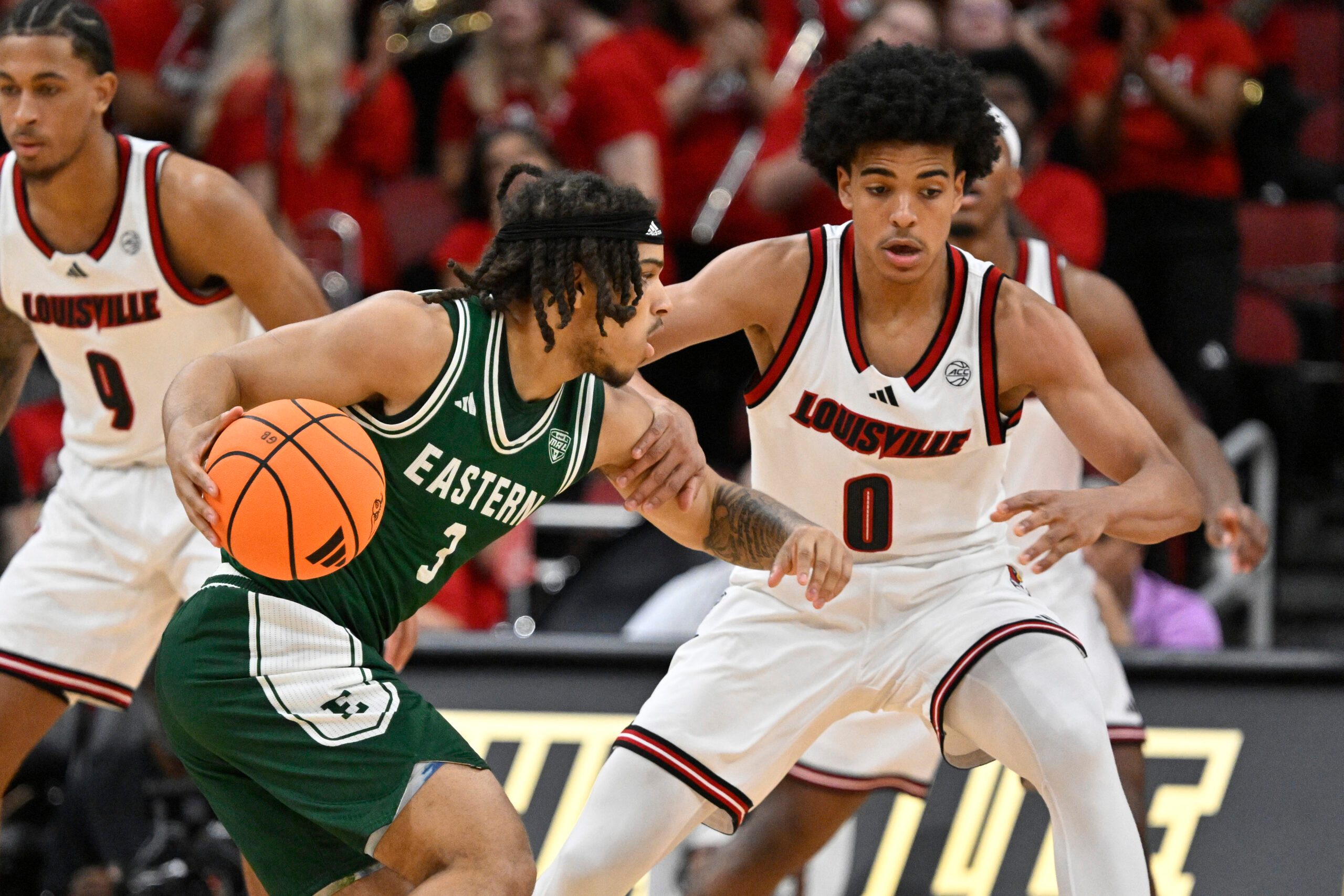 Nov 24, 2025; Louisville, Kentucky, USA; Eastern Michigan Eagles guard Mehki Ellison (3) dribbles against Louisville Cardinals guard Mikel Brown Jr. (0) during the second half at KFC Yum! Center. Louisville defeated Eastern Michigan 87-46. Mandatory Credit: Jamie Rhodes-Imagn Images