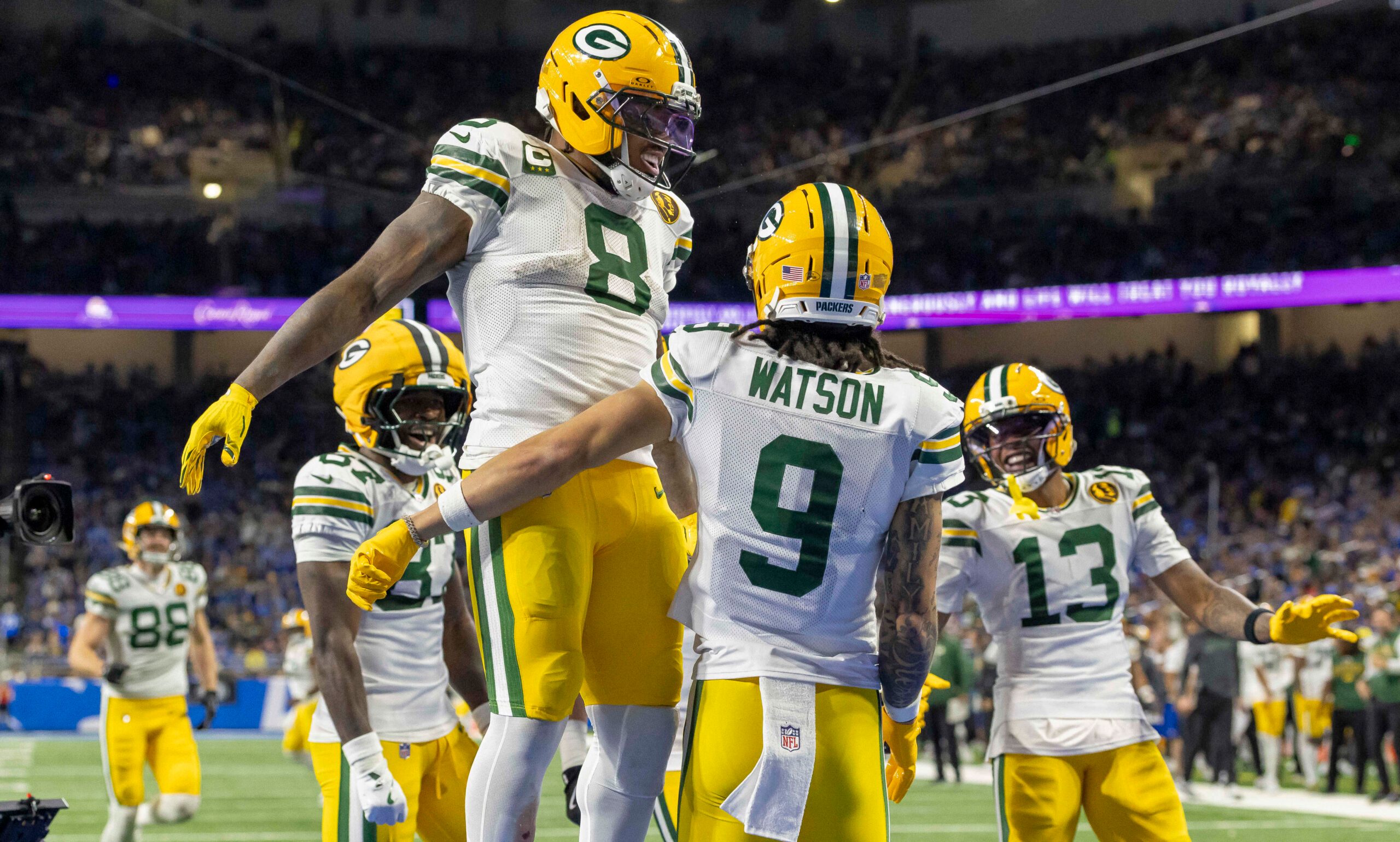 Nov 27, 2025; Detroit, Michigan, USA; Green Bay Packers running back Josh Jacobs (8) and Green Bay Packers wide receiver Christian Watson (9) celebrate after a touchdown against the Detroit Lions during the third quarter at Ford Field. Mandatory Credit: David Reginek-Imagn Images