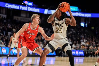 Nov 28, 2025; Winston-Salem, North Carolina, USA;  Wake Forest Demon Deacons forward Tre'Von Spillers (25) handles the ball against Northeastern Huskies forward Youri Fritz (7) during the first half at Lawrence Joel Veterans Memorial Coliseum. Mandatory Credit: Jim Dedmon-Imagn Images