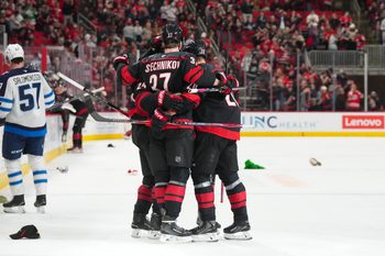Nov 28, 2025; Raleigh, North Carolina, USA;  Carolina Hurricanes center Seth Jarvis (24) is congratulated by right wing Andrei Svechnikov (37) and  center Sebastian Aho (20) after his empty net hat trick goal against the Winnipeg Jets during the third period at Lenovo Center. Mandatory Credit: James Guillory-Imagn Images