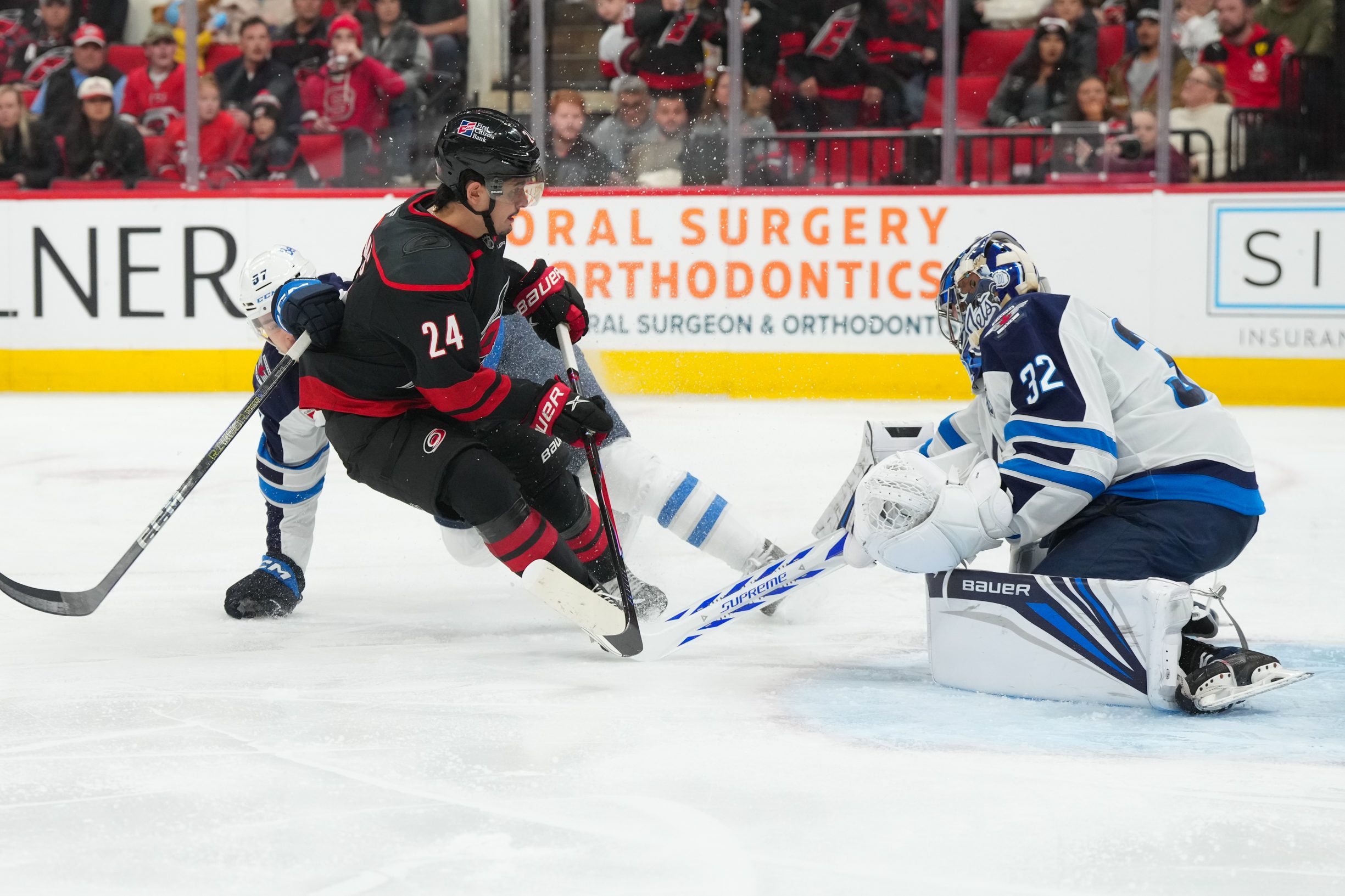 Nov 28, 2025; Raleigh, North Carolina, USA;  Carolina Hurricanes center Seth Jarvis (24) is stopped on his scoring attempt by Winnipeg Jets goaltender Thomas Milic (32) during the third period at Lenovo Center. Mandatory Credit: James Guillory-Imagn Images