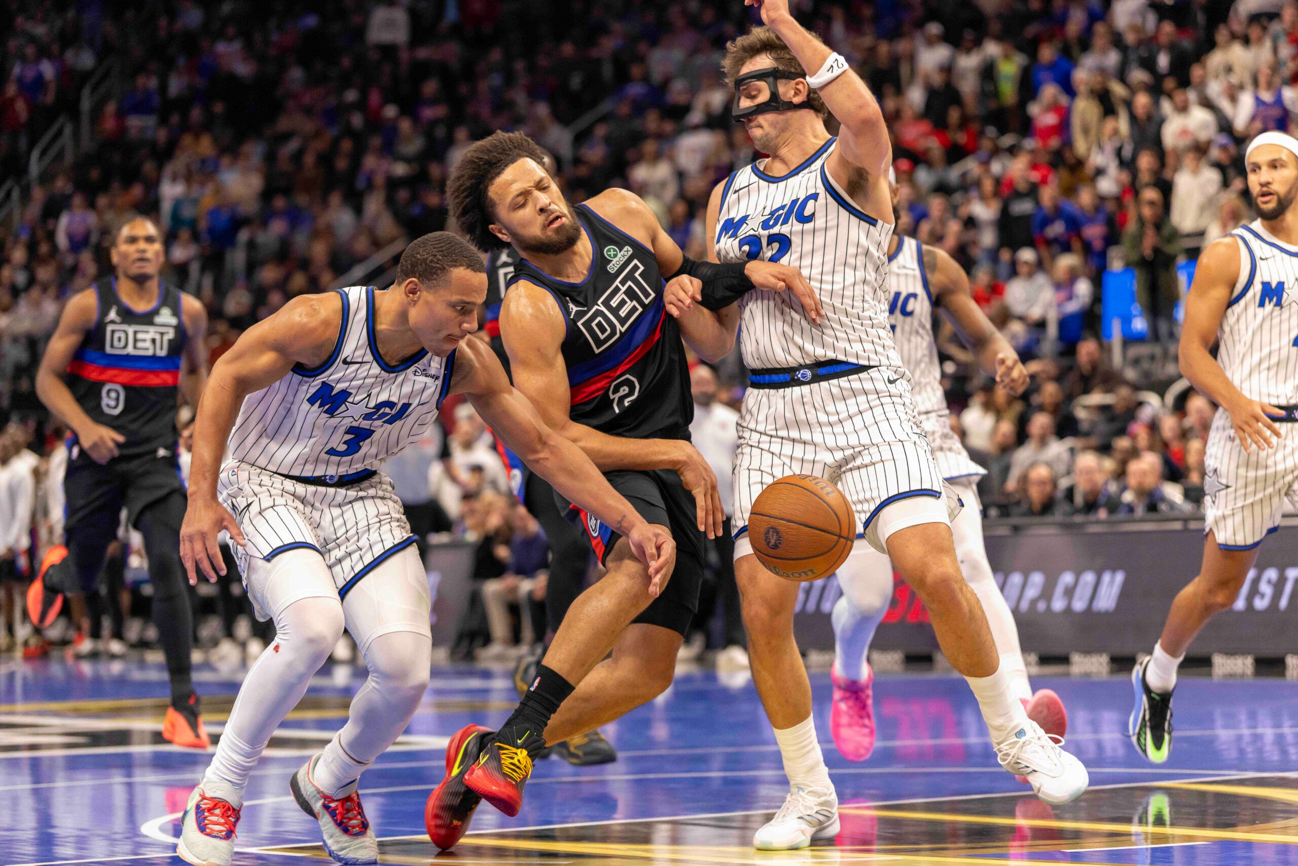Nov 28, 2025; Detroit, Michigan, USA; Orlando Magic forward Franz Wagner (22) and guard Desmond Bane (3) defends against Detroit Pistons guard Cade Cunningham (2) in the second half of the annual in-season NBA Cup tournament at Little Caesars Arena. Mandatory Credit: David Reginek-Imagn Images