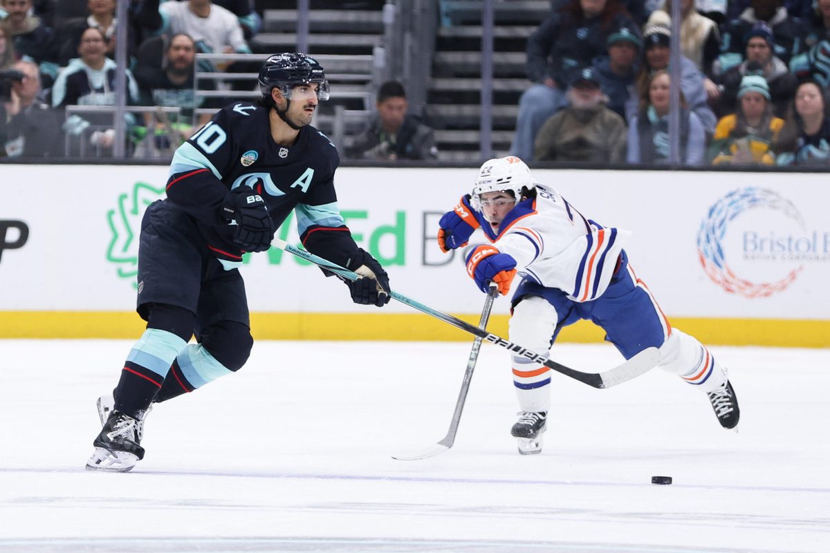 Nov 29, 2025; Seattle, Washington, USA; Seattle Kraken center Matty Beniers (10) passes the puck in the first period against the Edmonton Oilers at Climate Pledge Arena. Mandatory Credit: Kevin Ng-Imagn Images