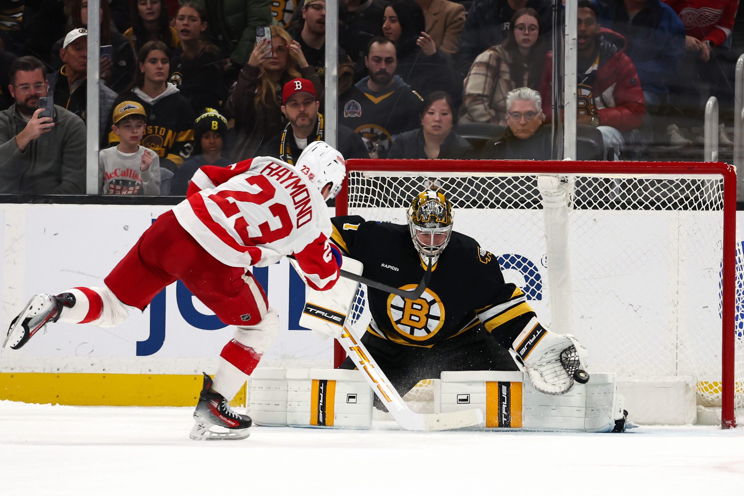 Nov 29, 2025; Boston, Massachusetts, USA; Boston Bruins goaltender Jeremy Swayman (1) gets his glove on a shot during a shootout by Detroit Red Wings left wing Lucas Raymond (23) at TD Garden. Mandatory Credit: Winslow Townson-Imagn Images