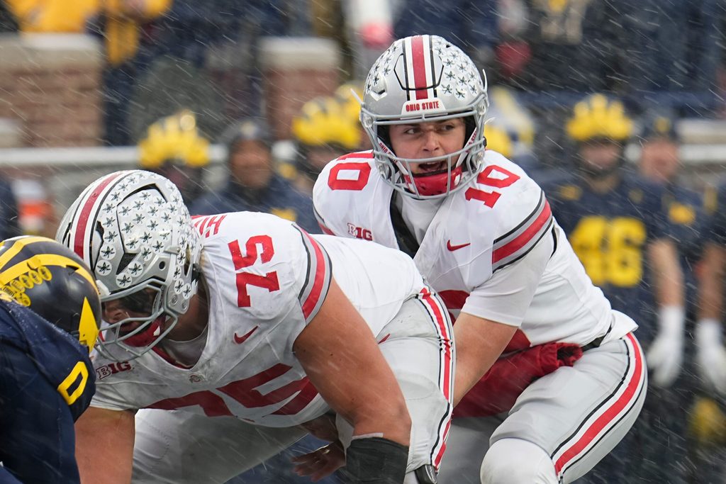 Ohio State Buckeyes quarterback Julian Sayin (10) takes a snap from offensive lineman Carson Hinzman (75) during the NCAA football game against the Michigan Wolverines at Michigan Stadium in Ann Arbor, Mich. on Nov. 29, 2025. Ohio State won 27-9.