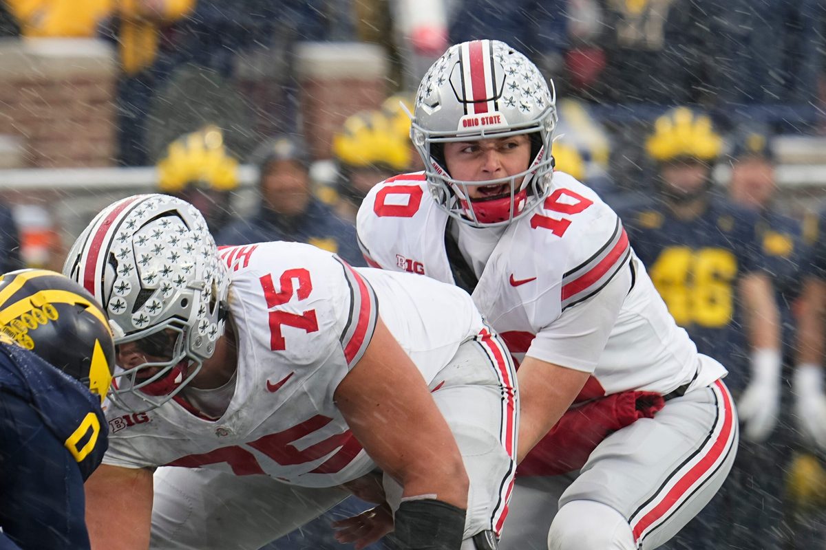 Ohio State Buckeyes quarterback Julian Sayin (10) takes a snap from offensive lineman Carson Hinzman (75) during the NCAA football game against the Michigan Wolverines at Michigan Stadium in Ann Arbor, Mich. on Nov. 29, 2025. Ohio State won 27-9.
