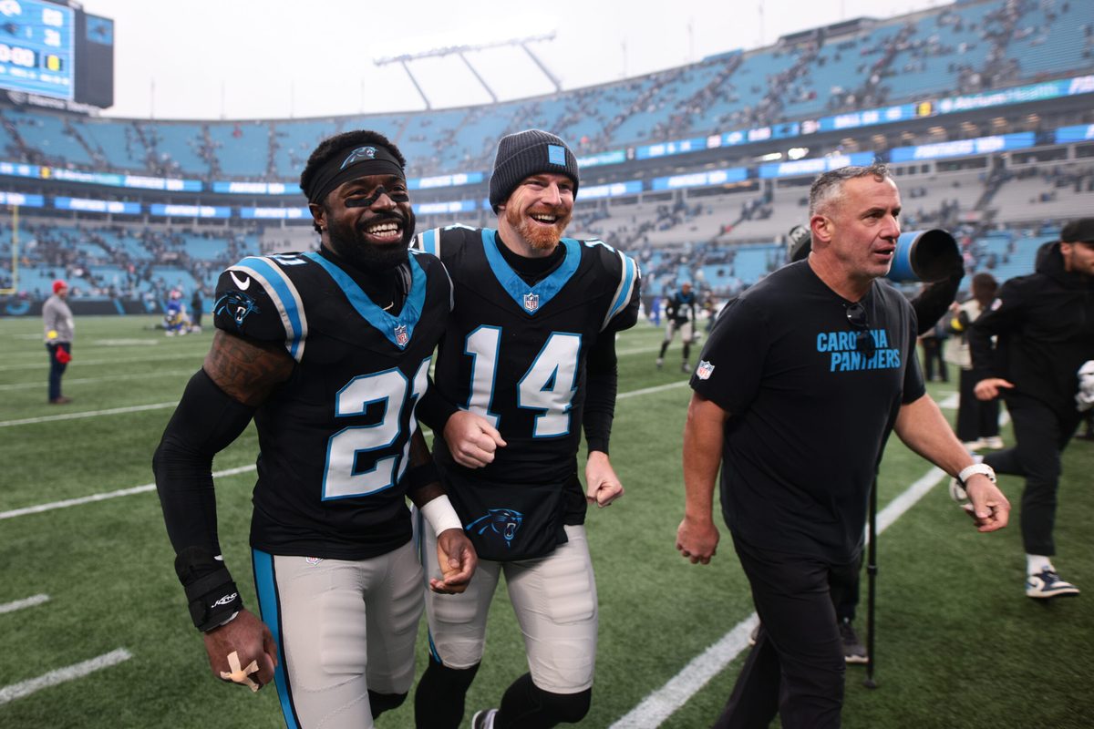 Nov 30, 2025; Charlotte, North Carolina, USA; Carolina Panthers safety Nick Scott (21) and Carolina Panthers quarterback Andy Dalton (14) celebrate after the game against the Los Angeles Rams at Bank of America Stadium. Mandatory Credit: Scott Kinser-Imagn Images