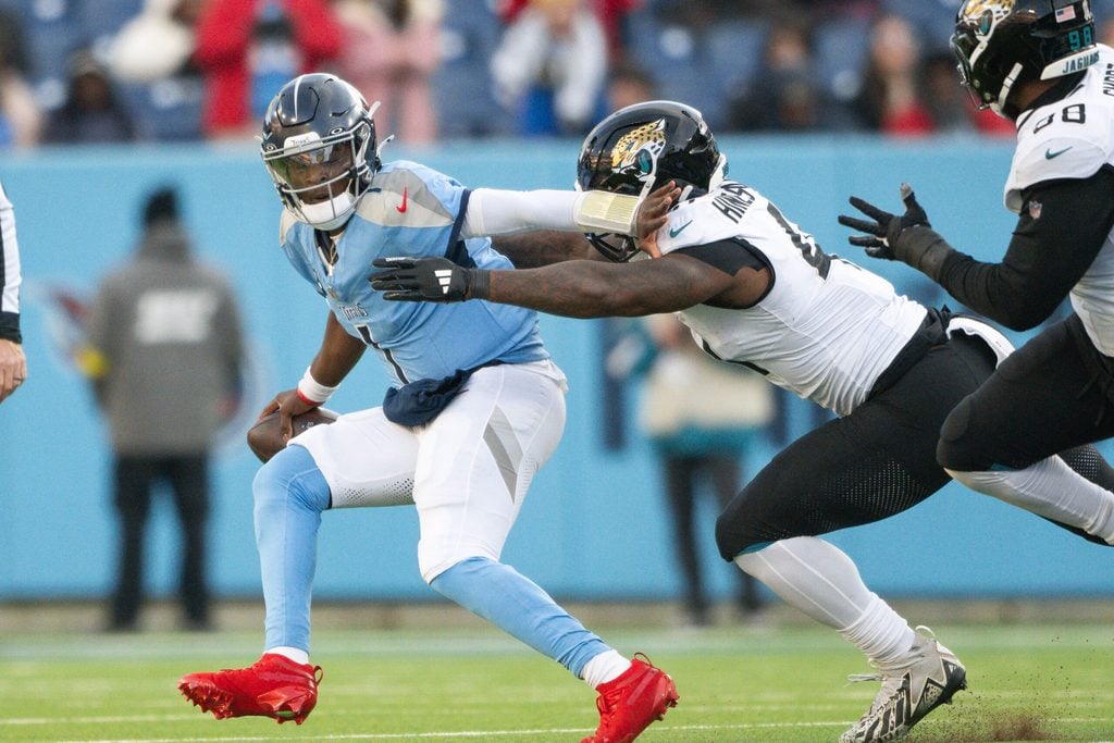 Nov 30, 2025; Nashville, Tennessee, USA; Jacksonville Jaguars defensive end Josh Hines-Allen (41) sacks Tennessee Titans quarterback Cameron Ward (1) during the second half at Nissan Stadium. Mandatory Credit: Steve Roberts-Imagn Images