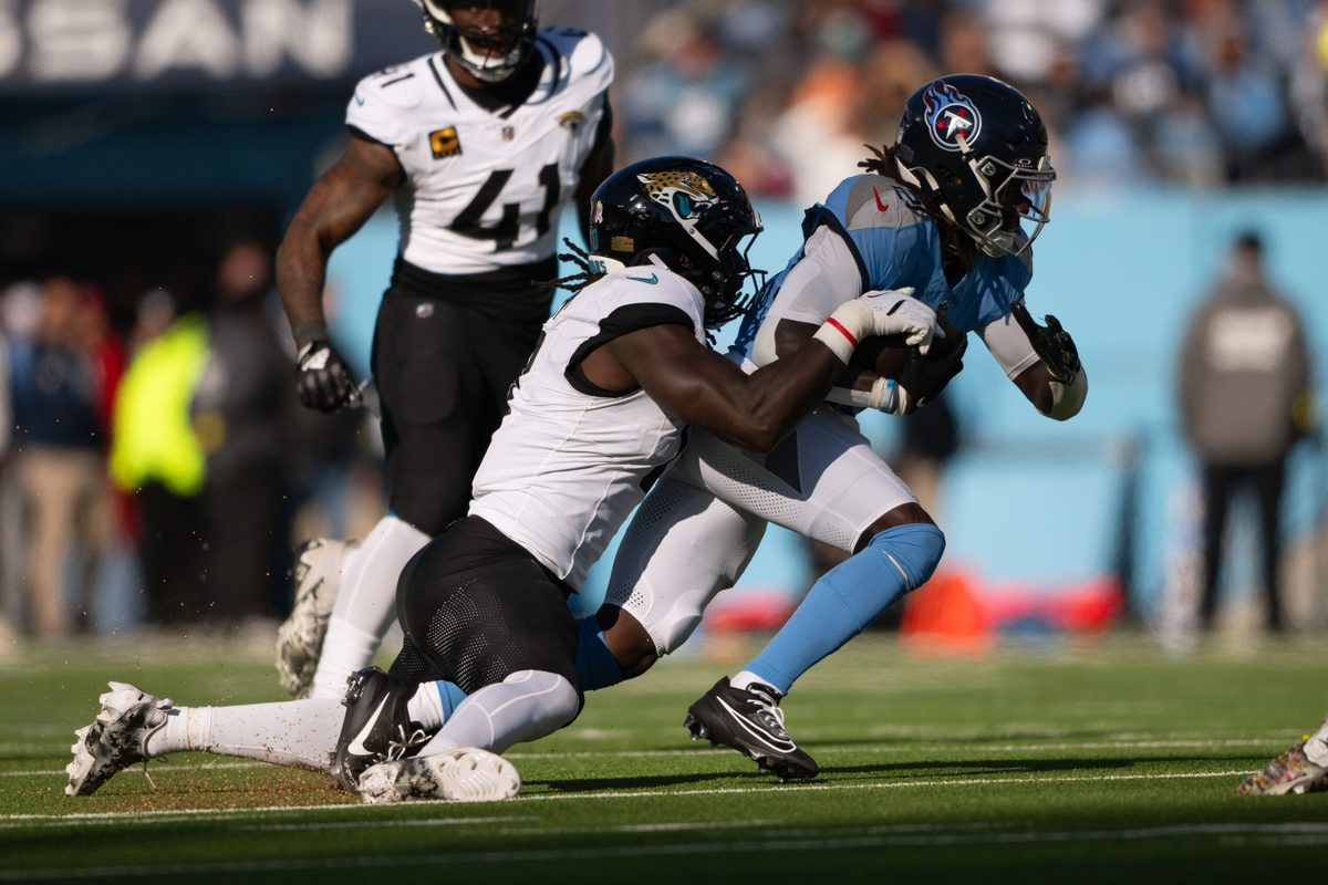 Nov 30, 2025; Nashville, Tennessee, USA;  Jacksonville Jaguars cornerback Montaric Brown (30) tackles Tennessee Titans running back Tyjae Spears (2) during the first half at Nissan Stadium. Mandatory Credit: Steve Roberts-Imagn Images
