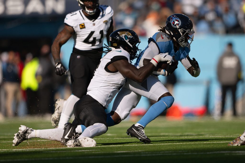 Nov 30, 2025; Nashville, Tennessee, USA; Jacksonville Jaguars cornerback Montaric Brown (30) tackles Tennessee Titans running back Tyjae Spears (2) during the first half at Nissan Stadium. Mandatory Credit: Steve Roberts-Imagn Images