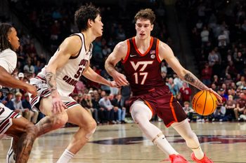 Dec 2, 2025; Columbia, South Carolina, USA; Virginia Tech Hokies guard Neoklis Avdalas (17) drives around South Carolina Gamecocks guard Mike Sharavjamts (55) in the second half at Colonial Life Arena. Mandatory Credit: Jeff Blake-Imagn Images