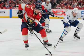 Dec 2, 2025; Sunrise, Florida, USA; Florida Panthers left wing Brad Marchand (63) moves the puck against Toronto Maple Leafs defenseman Morgan Rielly (44) during the third period at Amerant Bank Arena. Mandatory Credit: Sam Navarro-Imagn Images