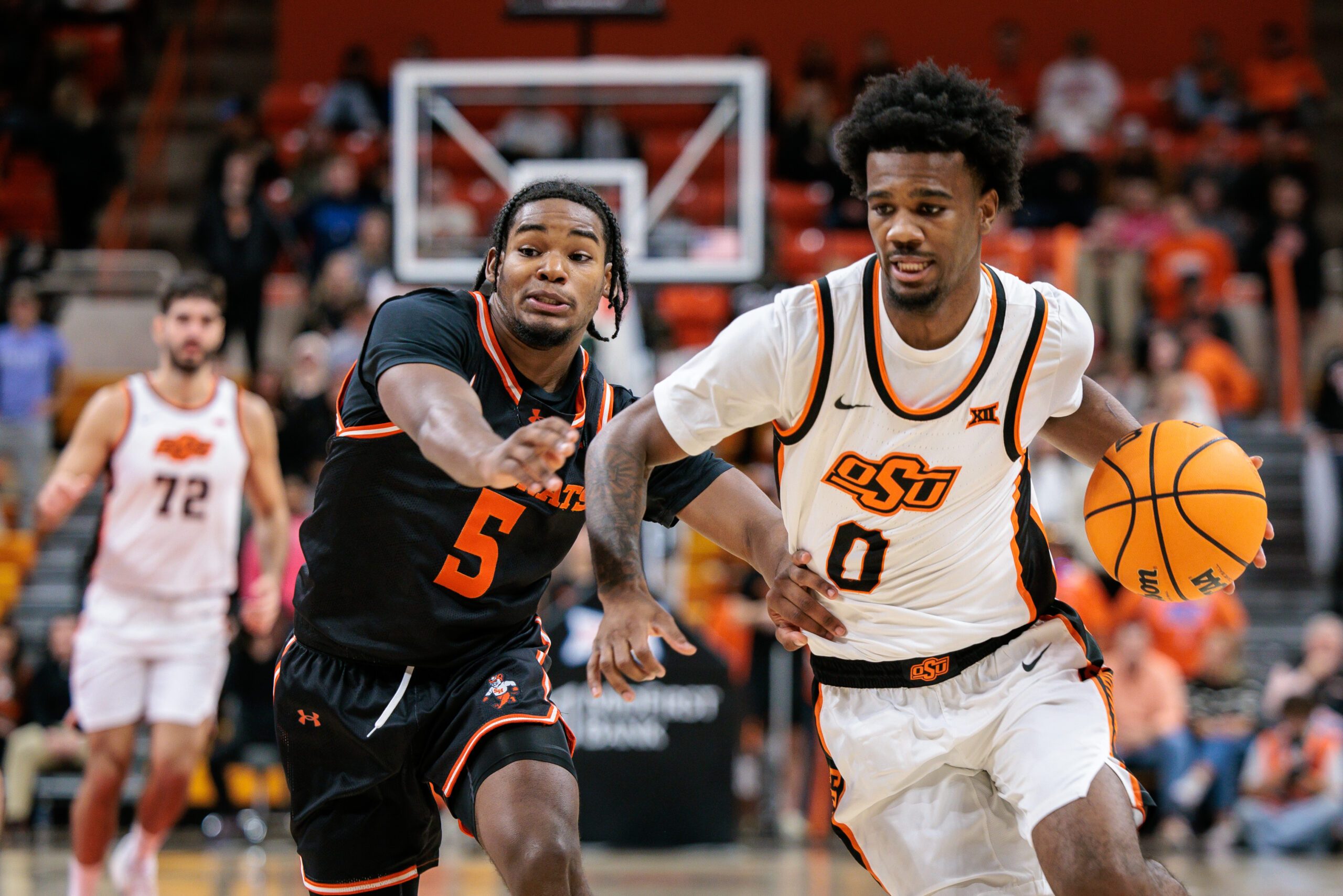Dec 2, 2025; Stillwater, Oklahoma, USA; Oklahoma State Cowboys guard Jaylen Curry (0) drives to the basket around Sam Houston Bearkats guard Justin Begg (5) during the first half at Gallagher-Iba Arena. Mandatory Credit: William Purnell-Imagn Images
