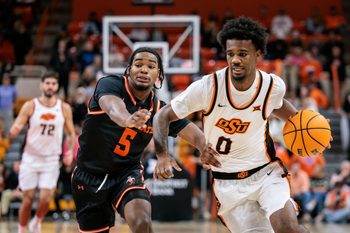 Dec 2, 2025; Stillwater, Oklahoma, USA; Oklahoma State Cowboys guard Jaylen Curry (0) drives to the basket around Sam Houston Bearkats guard Justin Begg (5) during the first half at Gallagher-Iba Arena. Mandatory Credit: William Purnell-Imagn Images