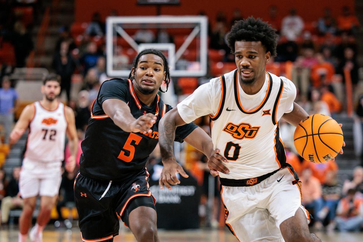 Dec 2, 2025; Stillwater, Oklahoma, USA; Oklahoma State Cowboys guard Jaylen Curry (0) drives to the basket around Sam Houston Bearkats guard Justin Begg (5) during the first half at Gallagher-Iba Arena. Mandatory Credit: William Purnell-Imagn Images