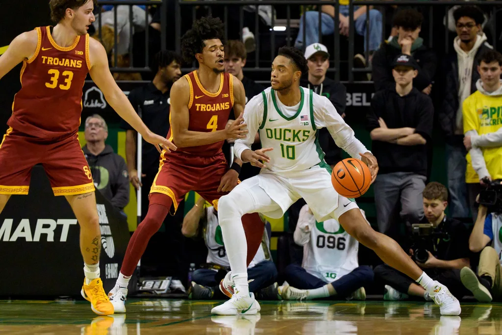Oregon forward Kwame Evans Jr., right, presses toward the basket under cover from USC guard Chad Baker-Mazara as the Oregon Ducks host the USC Trojans at Matthew Knight Arena in Eugene, Oregon on Dec. 2, 2025.