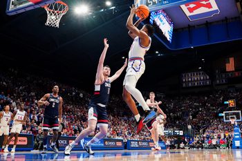 Dec 2, 2025; Lawrence, Kansas, USA; Kansas Jayhawks guard Elmarko Jackson (13) shoots as UConn Huskies forward Alex Karaban (11) defends during the second half of the game at Allen Fieldhouse. Mandatory Credit: Denny Medley-Imagn Images