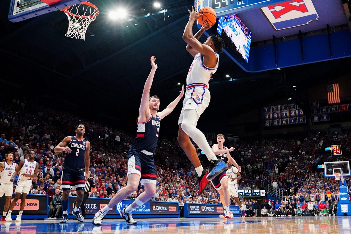 Dec 2, 2025; Lawrence, Kansas, USA; Kansas Jayhawks guard Elmarko Jackson (13) shoots as UConn Huskies forward Alex Karaban (11) defends during the second half of the game at Allen Fieldhouse. Mandatory Credit: Denny Medley-Imagn Images