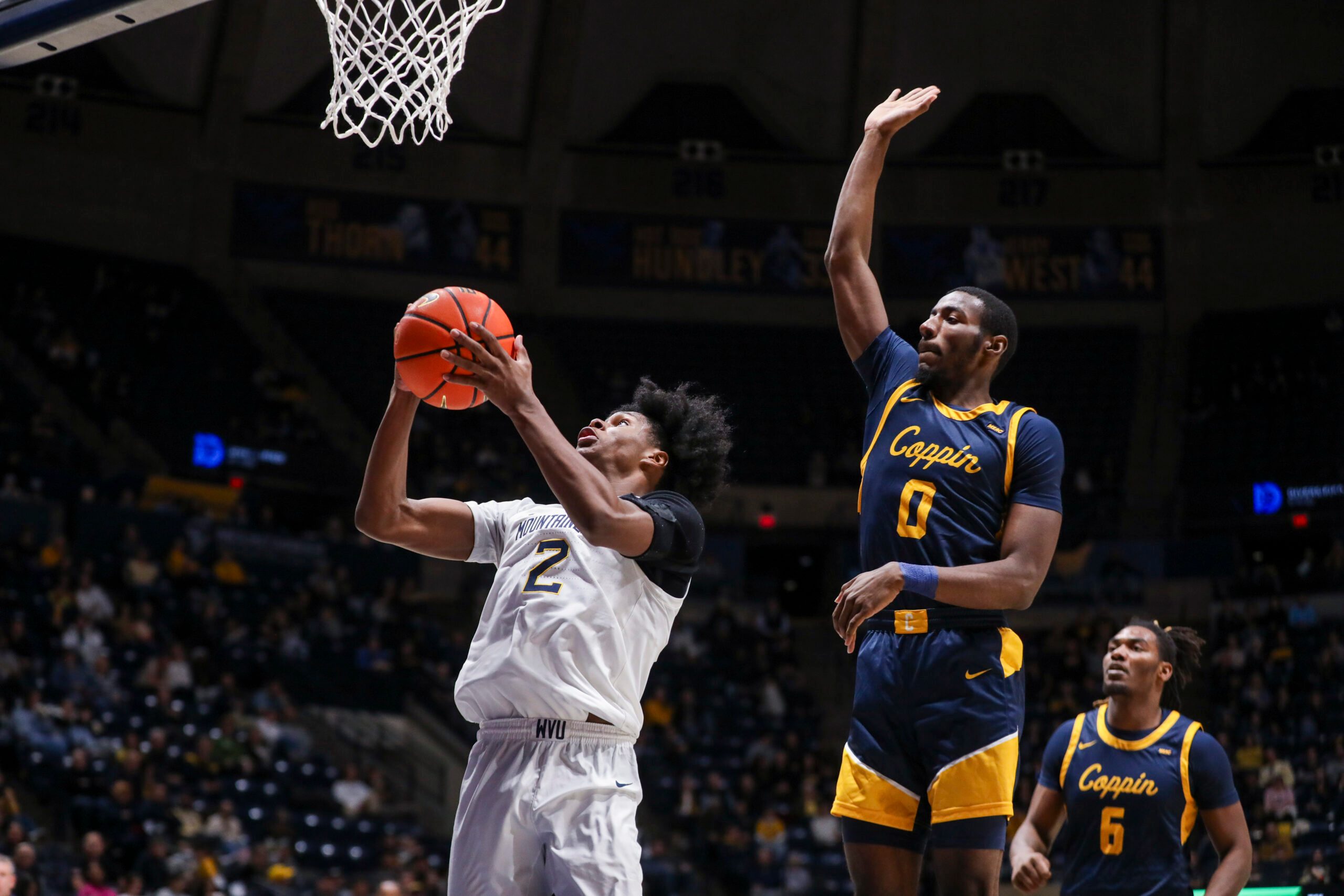 Dec 3, 2025; Morgantown, West Virginia, USA; West Virginia Mountaineers guard Amir Jenkins (2) shoots in the lane while defended by Coppin State Eagles guard Baasil Saunders (0) during the second half at Hope Coliseum. Mandatory Credit: Ben Queen-Imagn Images
