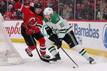 Dec 3, 2025; Newark, New Jersey, USA; Dallas Stars left wing Jason Robertson (21) skates with the puck as New Jersey Devils defenseman Luke Hughes (43) defends during the third period at Prudential Center. Mandatory Credit: Ed Mulholland-Imagn Images