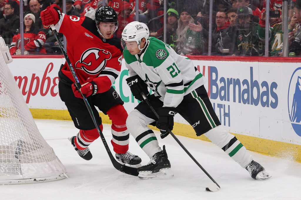 Dec 3, 2025; Newark, New Jersey, USA; Dallas Stars left wing Jason Robertson (21) skates with the puck as New Jersey Devils defenseman Luke Hughes (43) defends during the third period at Prudential Center. Mandatory Credit: Ed Mulholland-Imagn Images