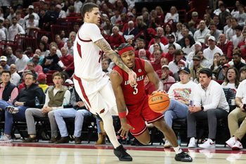 Dec 3, 2025; Fayetteville, Arkansas, USA; Louisville Cardinals guard Ryan Conwell (3) drives against Arkansas Razorbacks forward Trevon Brazile (7) during the second half at Bud Walton Arena. Arkansas won 89-80. Mandatory Credit: Nelson Chenault-Imagn Images