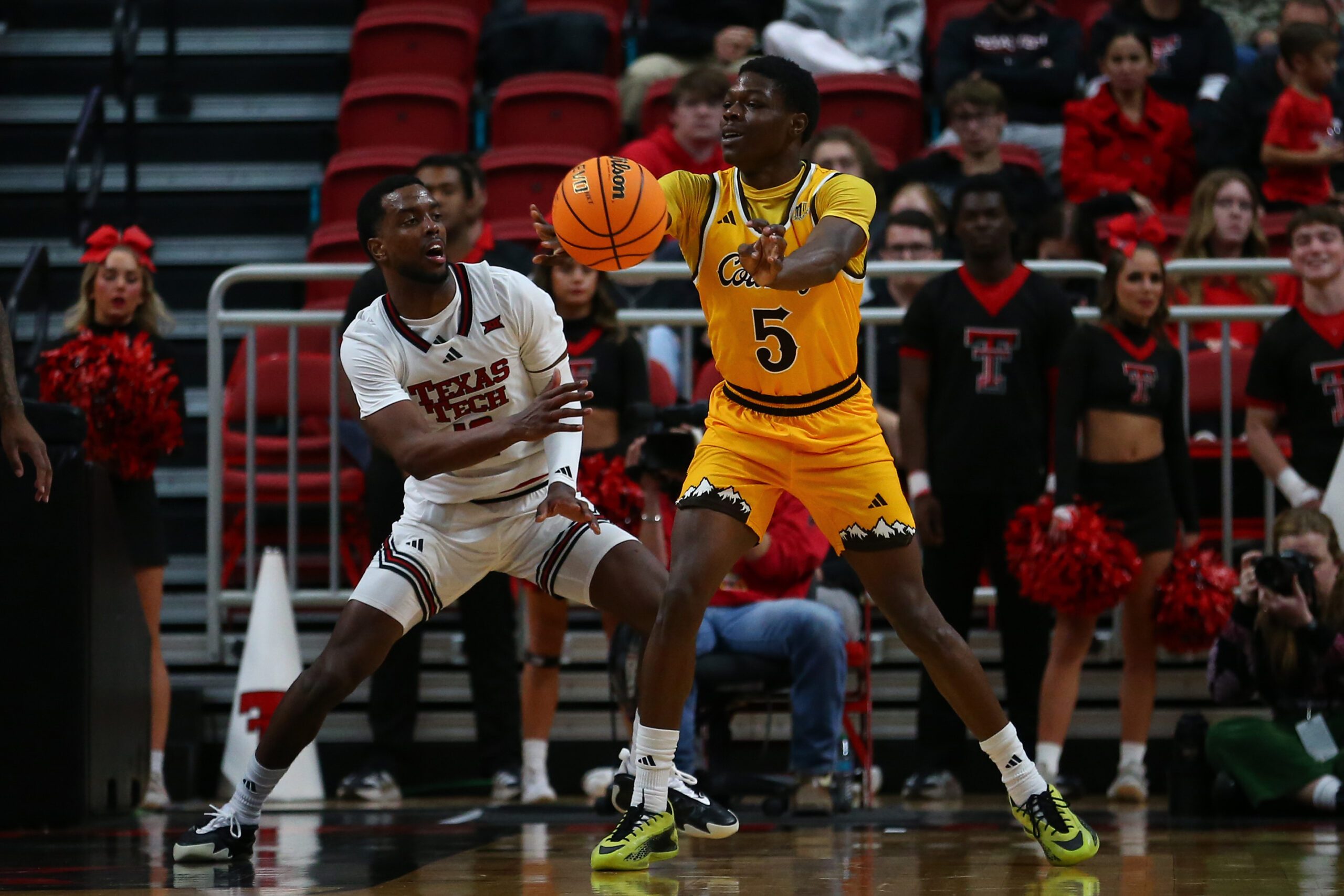Nov 30, 2025; Lubbock, Texas, USA;  Wyoming Cowboys guard Leland Walker (5) passes the ball in front of Texas Tech Red Raiders guard Donovan Atwell (12) in the second half at United Supermarkets Arena. Mandatory Credit: Michael C. Johnson-Imagn Images