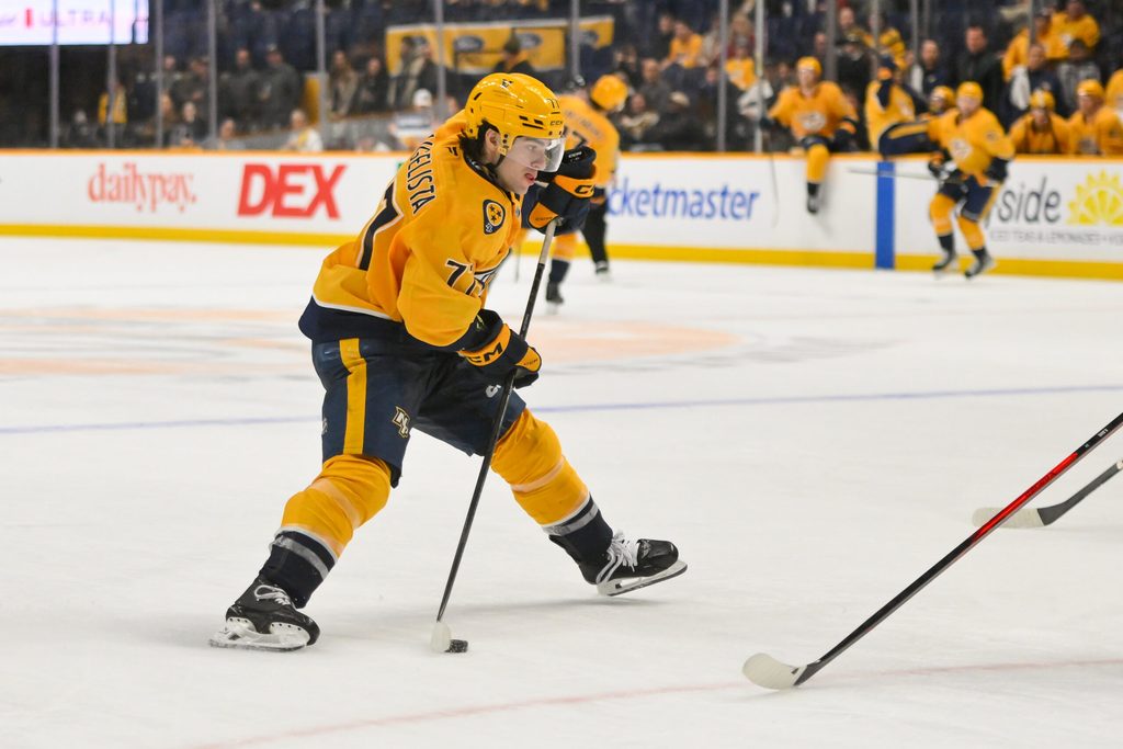 Dec 2, 2025; Nashville, Tennessee, USA; Nashville Predators right wing Luke Evangelista (77) takes a shot on goal against the Calgary Flames during the third period at Bridgestone Arena. Mandatory Credit: Steve Roberts-Imagn Images
