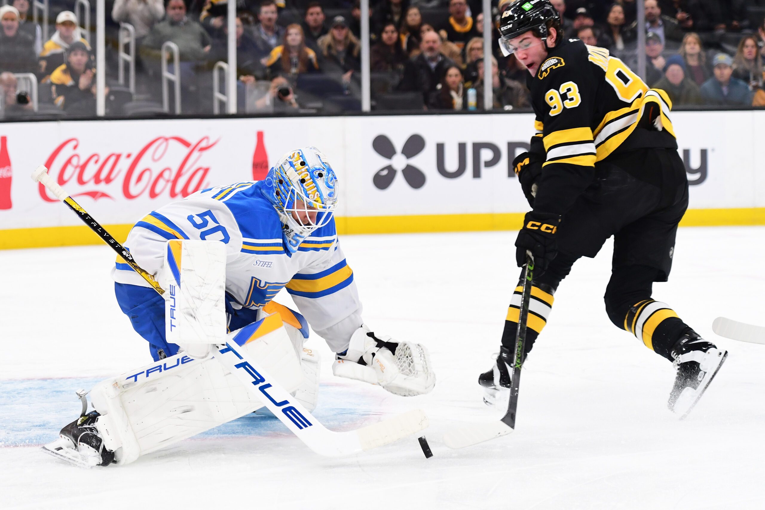 Dec 4, 2025; Boston, Massachusetts, USA; St. Louis Blues goaltender Jordan Binnington (50) makes a save on Boston Bruins center Fraser Minten (93) during the first period at TD Garden. Mandatory Credit: Bob DeChiara-Imagn Images