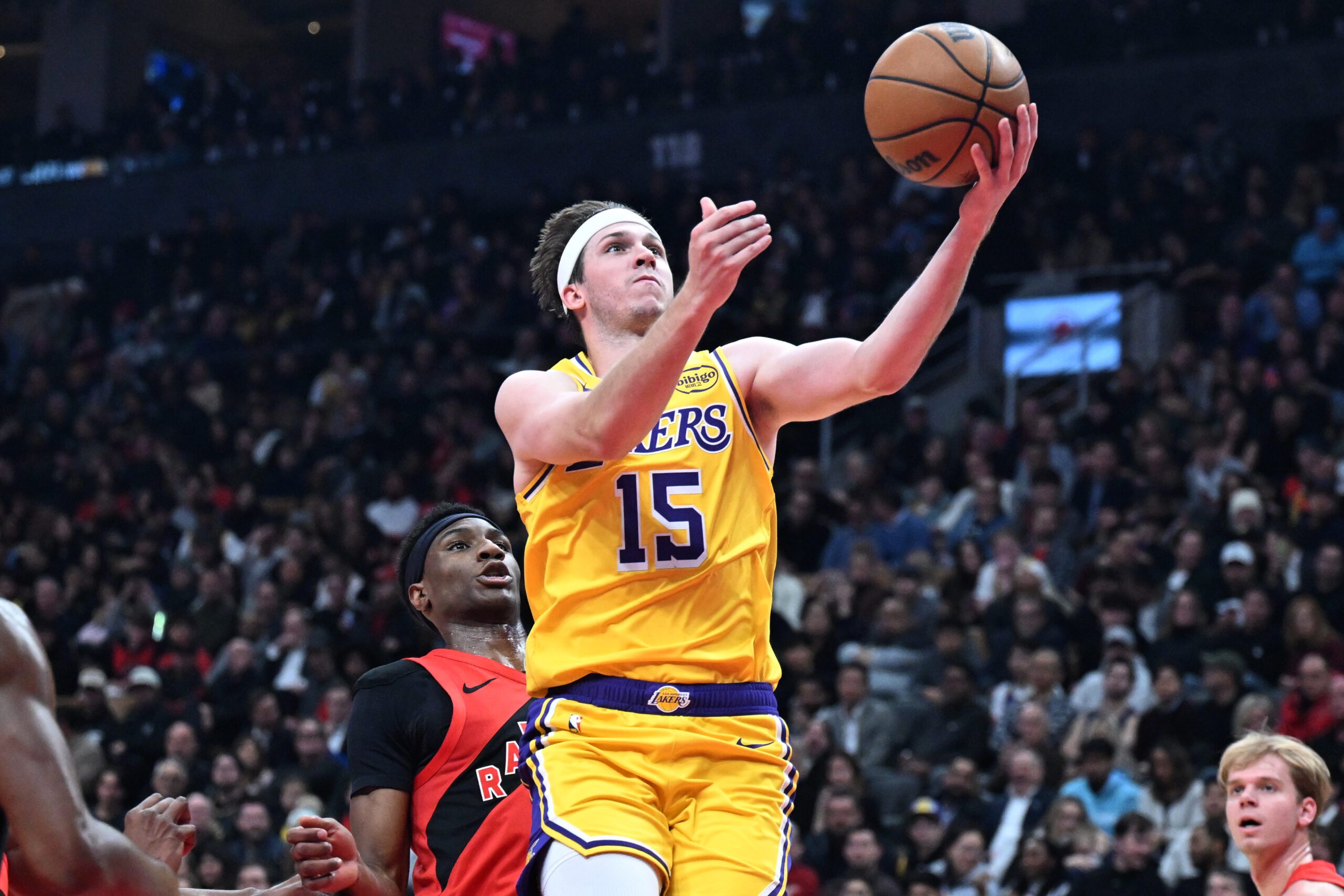 Dec 4, 2025; Toronto, Ontario, CAN;  Los Angeles Lakers guard Austin Reaves (15) drives to the basket past Toronto Raptors guard Ja'Kobe Walter (14) in the first half at Scotiabank Arena. Mandatory Credit: Dan Hamilton-Imagn Images
