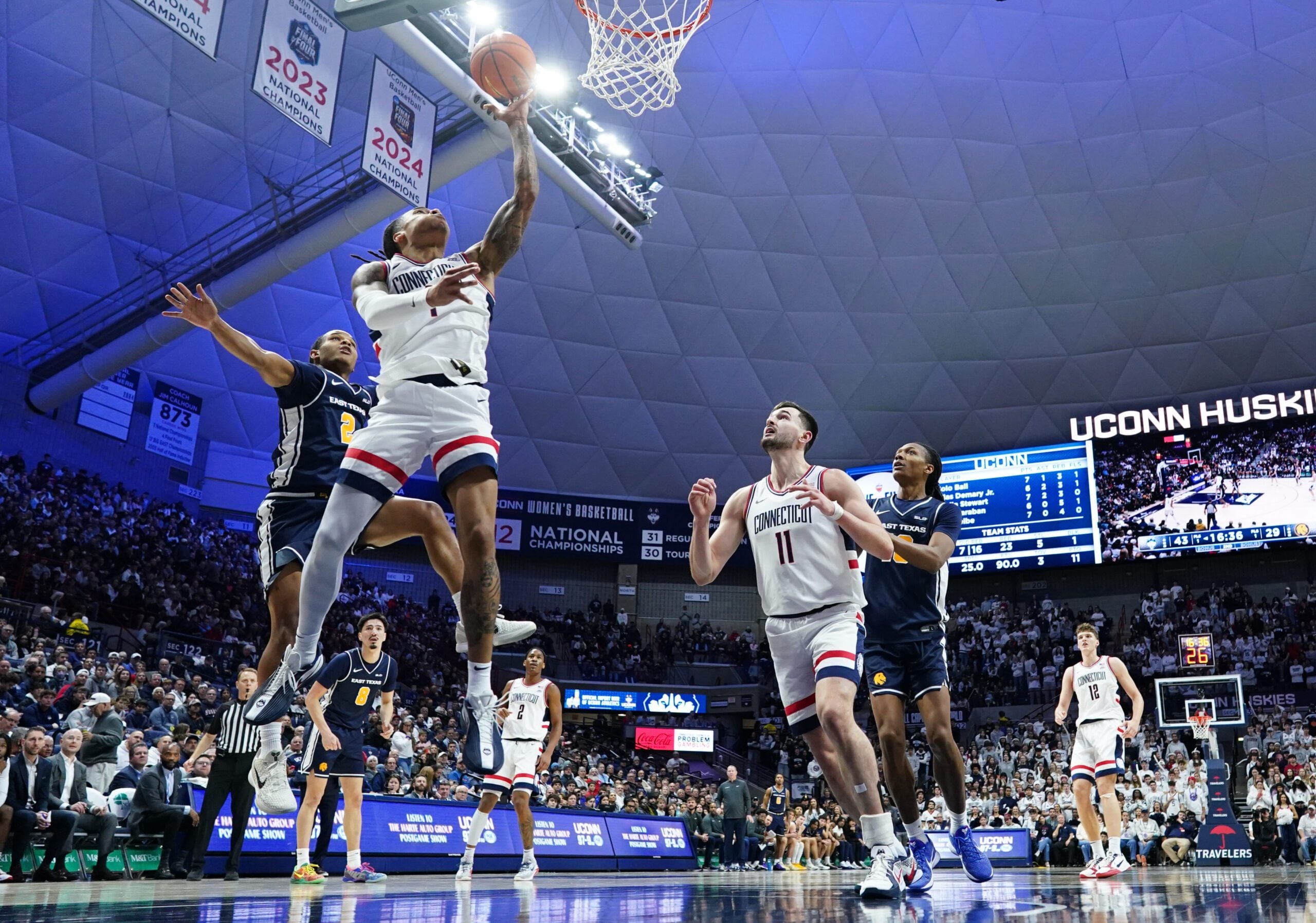 Dec 5, 2025; Storrs, Connecticut, USA; UConn Huskies guard Solo Ball (1) makes the basket against East Texas A&M Lions guard Evan Phelps (2) in the second half at Harry A. Gampel Pavilion. Mandatory Credit: David Butler II-Imagn Images