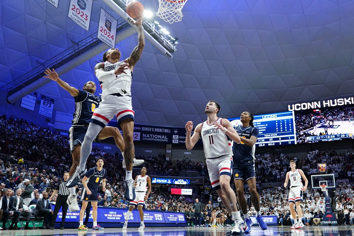 Dec 5, 2025; Storrs, Connecticut, USA; UConn Huskies guard Solo Ball (1) makes the basket against East Texas A&M Lions guard Evan Phelps (2) in the second half at Harry A. Gampel Pavilion. Mandatory Credit: David Butler II-Imagn Images