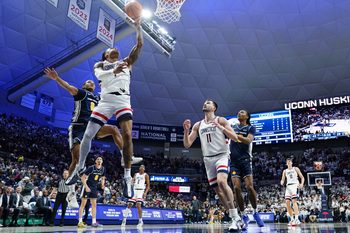 Dec 5, 2025; Storrs, Connecticut, USA; UConn Huskies guard Solo Ball (1) makes the basket against East Texas A&M Lions guard Evan Phelps (2) in the second half at Harry A. Gampel Pavilion. Mandatory Credit: David Butler II-Imagn Images